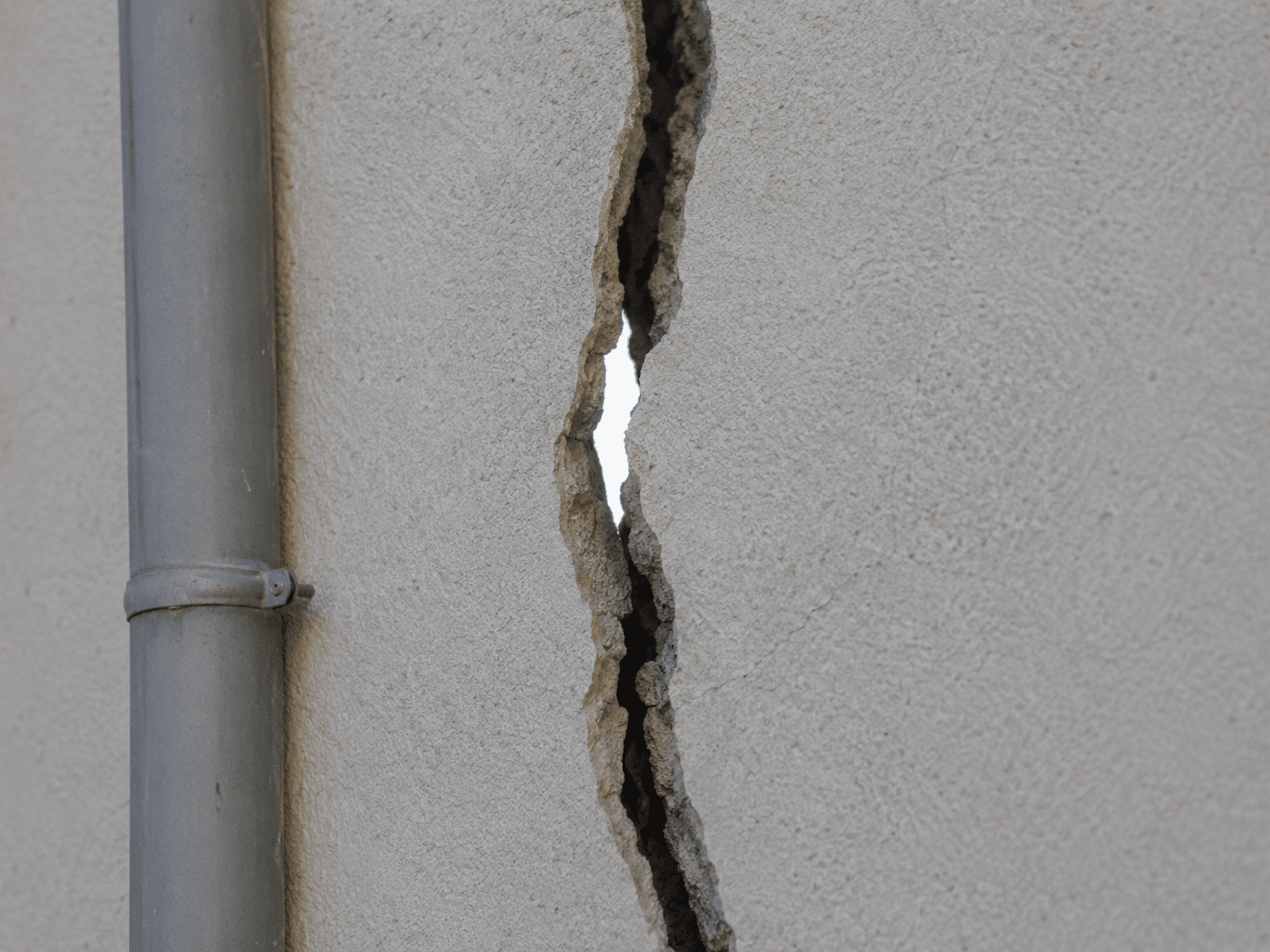 Fissure traversante laissant passer la lumière à travers un mur