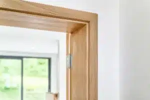 Huisserie en bois, cadre fixe d'une porte intérieure avec ses gonds