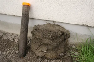 Échantillon de sol argileux prélevé près d'une maison pour une étude géotechnique liée aux fissures