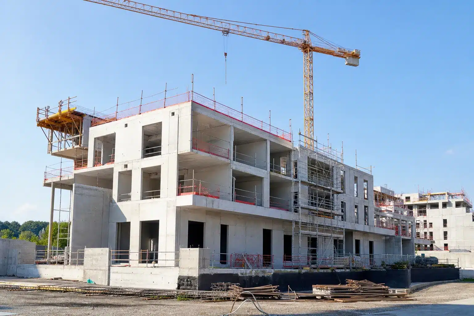 Chantier de construction d'un immeuble résidentiel neuf en VEFA au stade du gros œuvre avec grue et échafaudages
