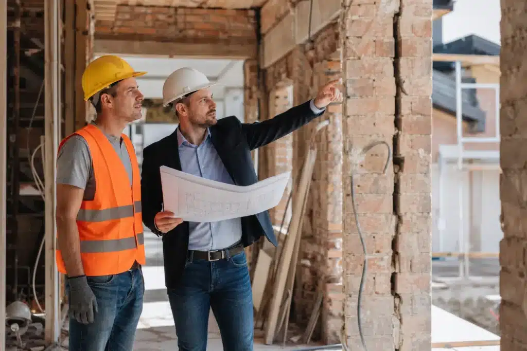 Architecte en visite de chantier verifiant les travaux avec une entreprise