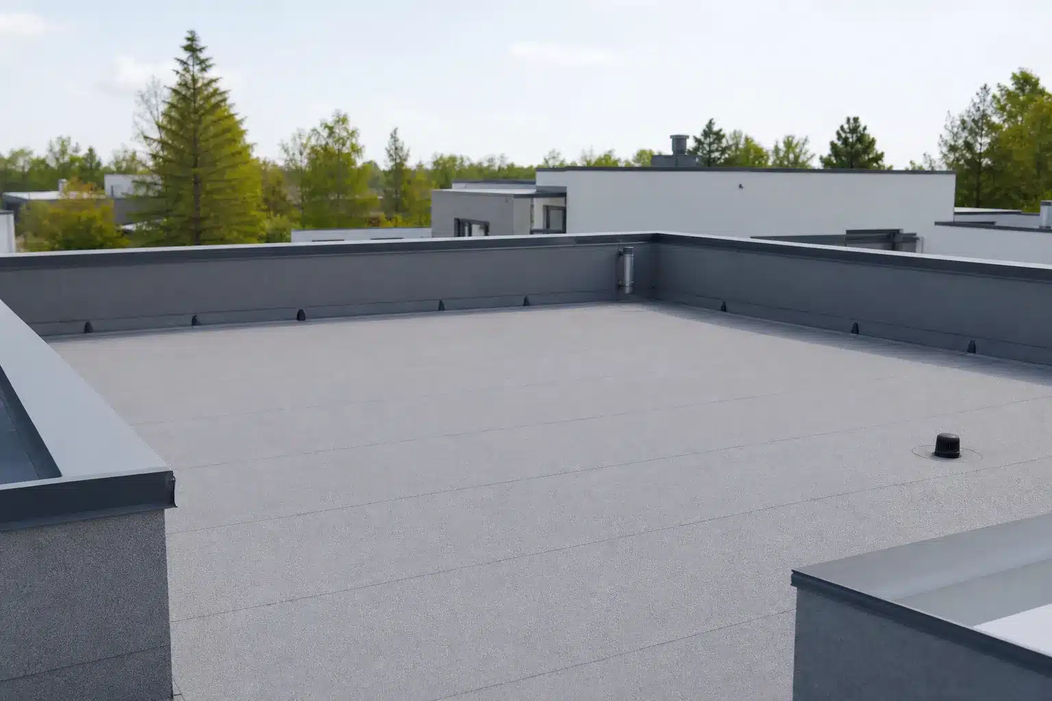 Toiture-terrasse avec étanchéité, acrotères et évacuations d'un immeuble neuf, partie commune en VEFA