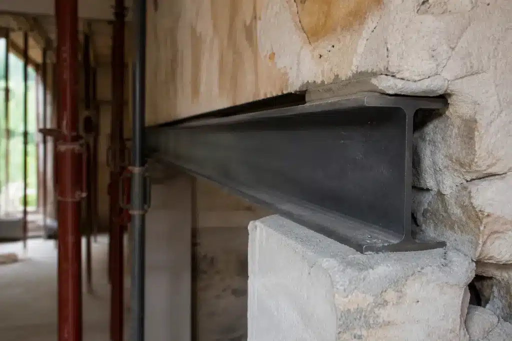 Extrémité d'une poutre métallique posée sur un sommier en béton dans l'ouverture d'un mur porteur, étais encore en place