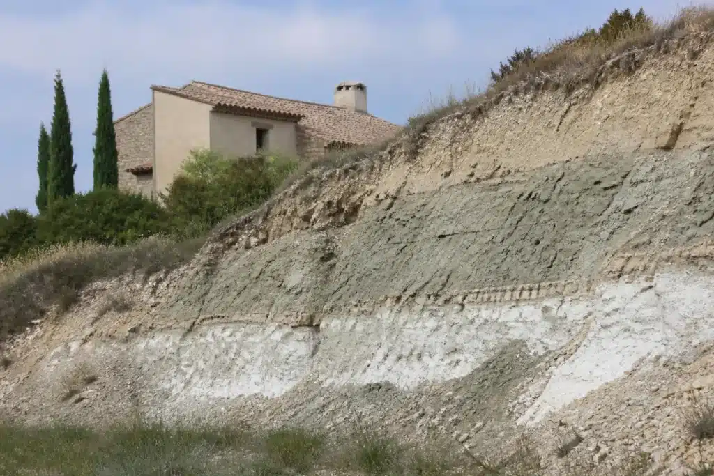 Couches d'argile, de marne et de gypse dans un talus près d'une maison