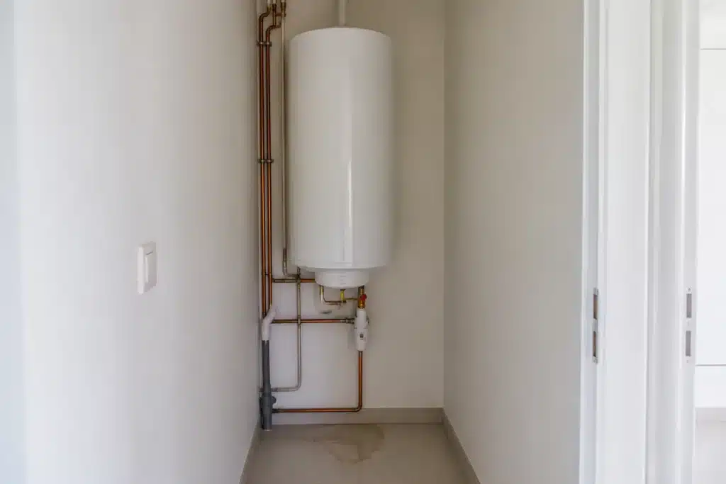 Ballon d'eau chaude installé dans le cellier d'un logement neuf, élément d'équipement relevant de la garantie de bon fonctionnement