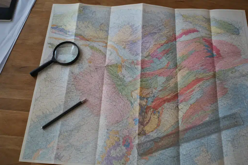 Carte de zonage des argiles consultée à la loupe sur un bureau