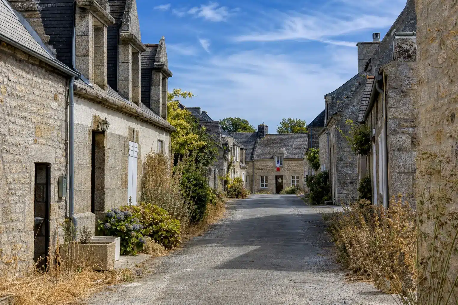 Rue de village en Ille-et-Vilaine après une sécheresse, mairie au fond
