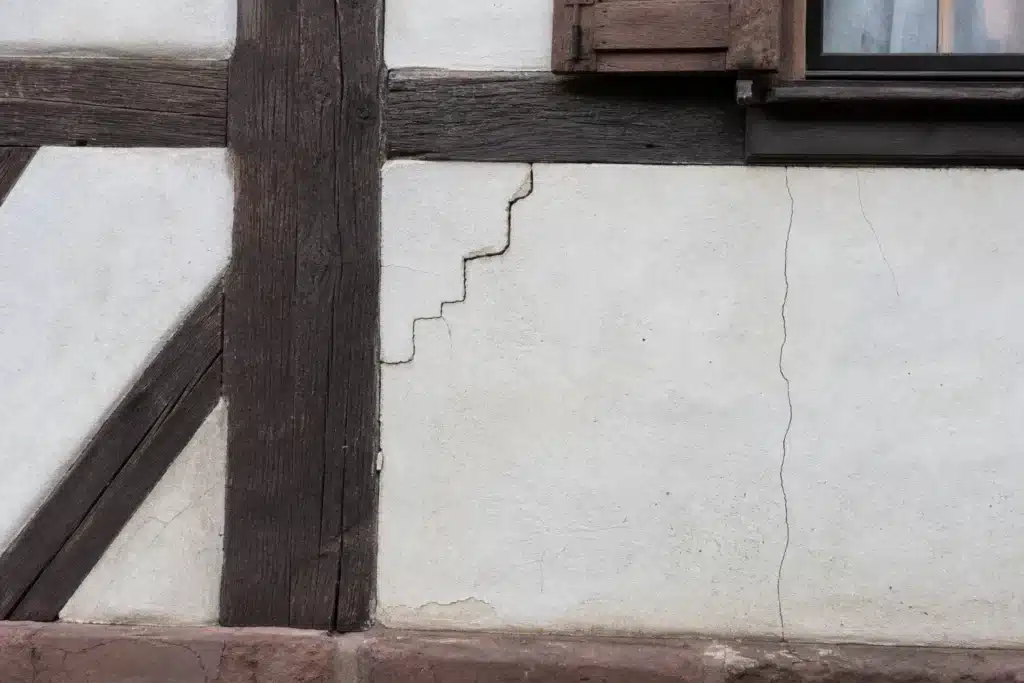Plusieurs types de fissures sur un mur extérieur, à distinguer par l'expertise