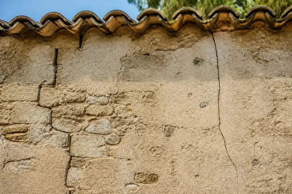 Plusieurs types de fissures sur un mur extérieur, à distinguer par l'expertise