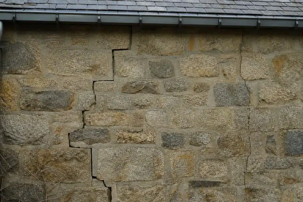 Plusieurs types de fissures sur un mur extérieur, à distinguer par l'expertise