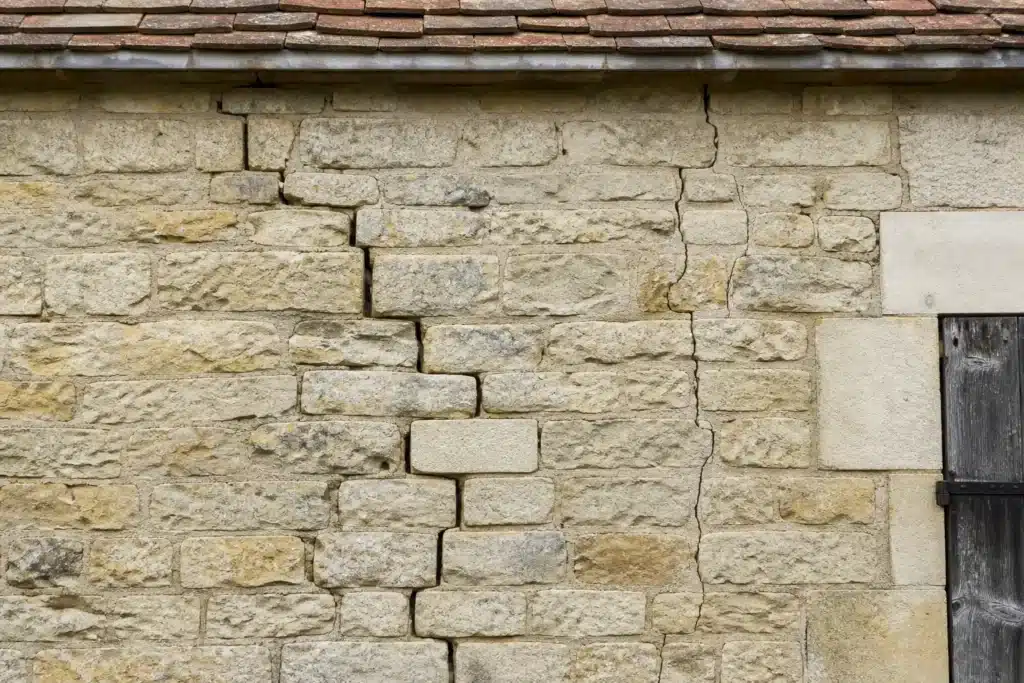 Plusieurs types de fissures sur un mur extérieur, à distinguer par l'expertise