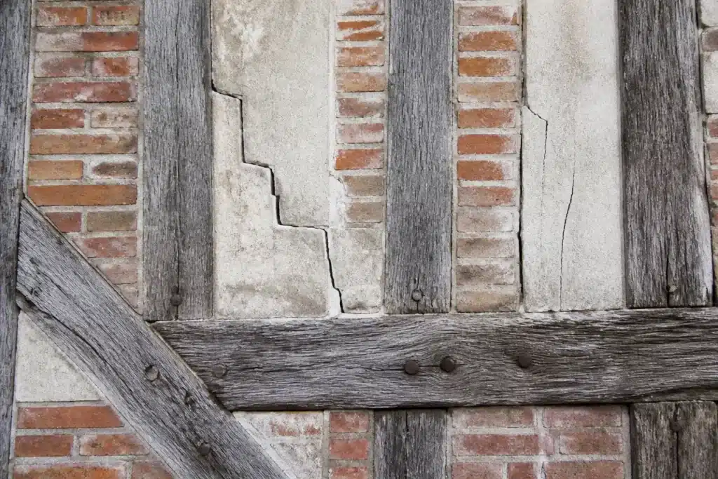 Plusieurs types de fissures sur un mur extérieur, à distinguer par l'expertise