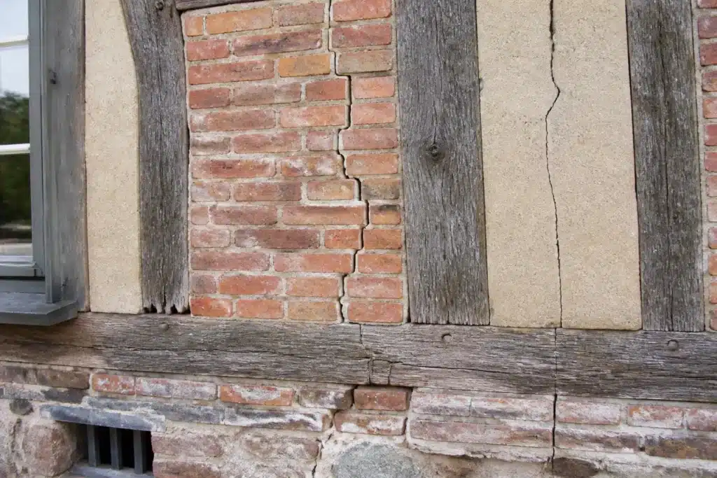 Plusieurs types de fissures sur un mur extérieur, à distinguer par l'expertise