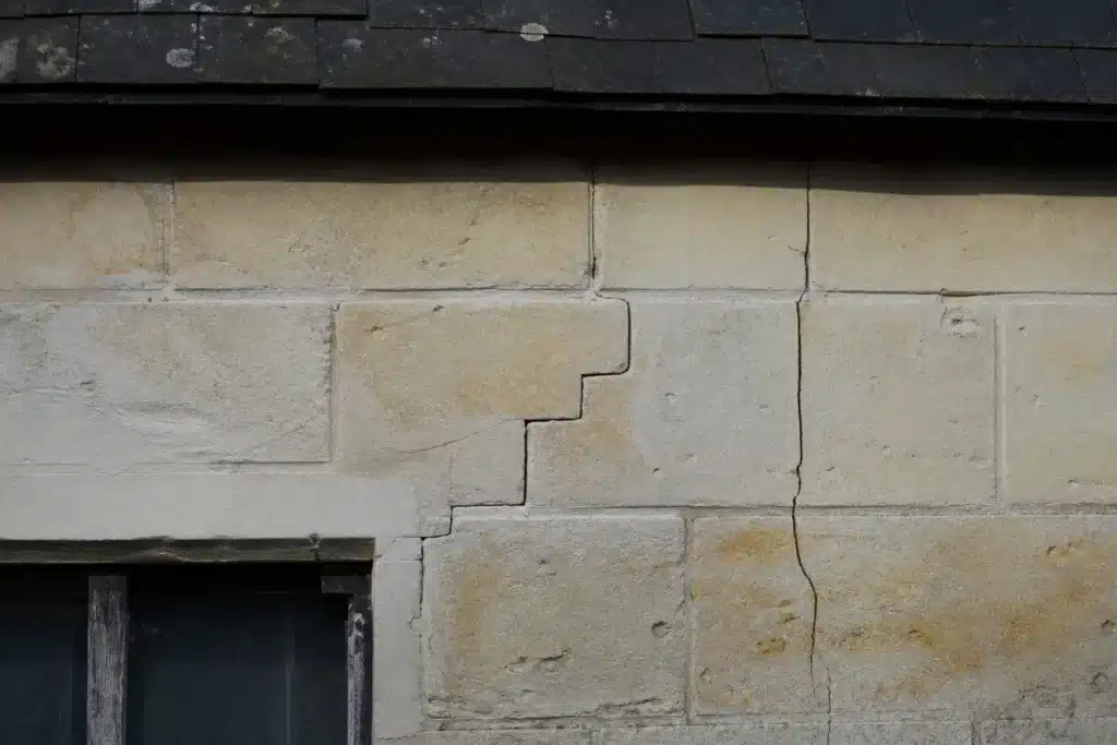 Plusieurs types de fissures sur un mur extérieur, à distinguer par l'expertise