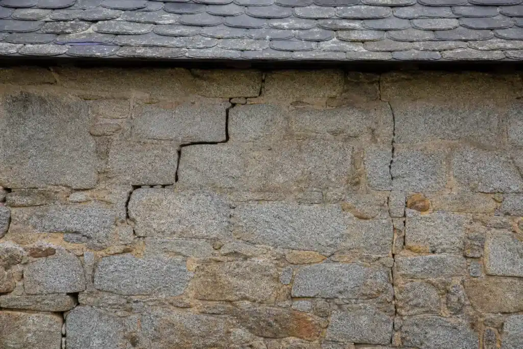 Plusieurs types de fissures sur un mur extérieur, à distinguer par l'expertise