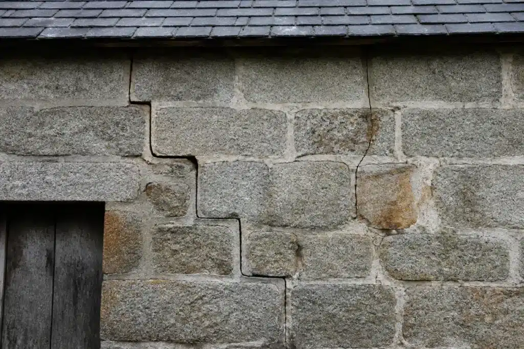Plusieurs types de fissures sur un mur extérieur, à distinguer par l'expertise