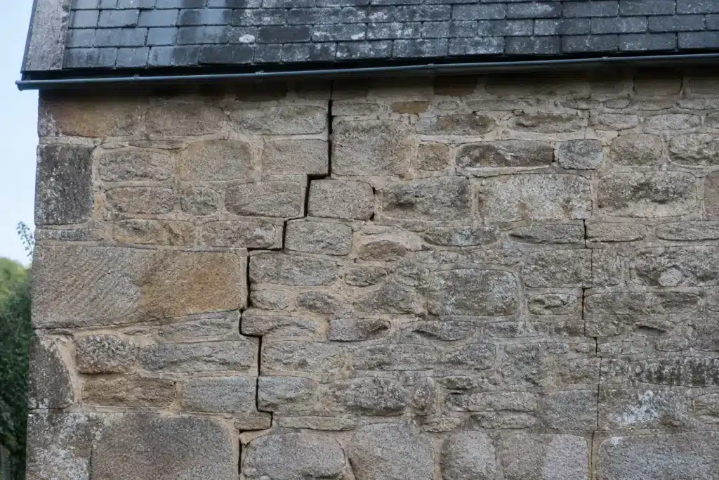 Plusieurs types de fissures sur un mur extérieur, à distinguer par l'expertise