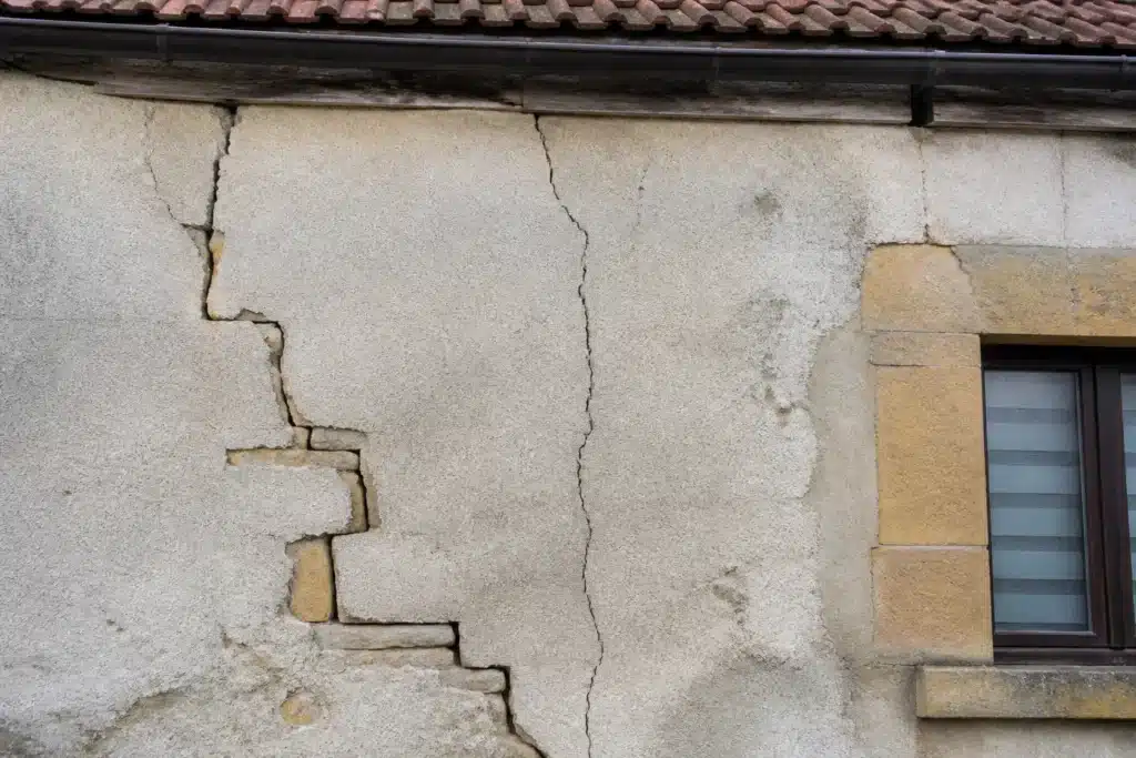 Plusieurs types de fissures sur un mur extérieur, à distinguer par l'expertise