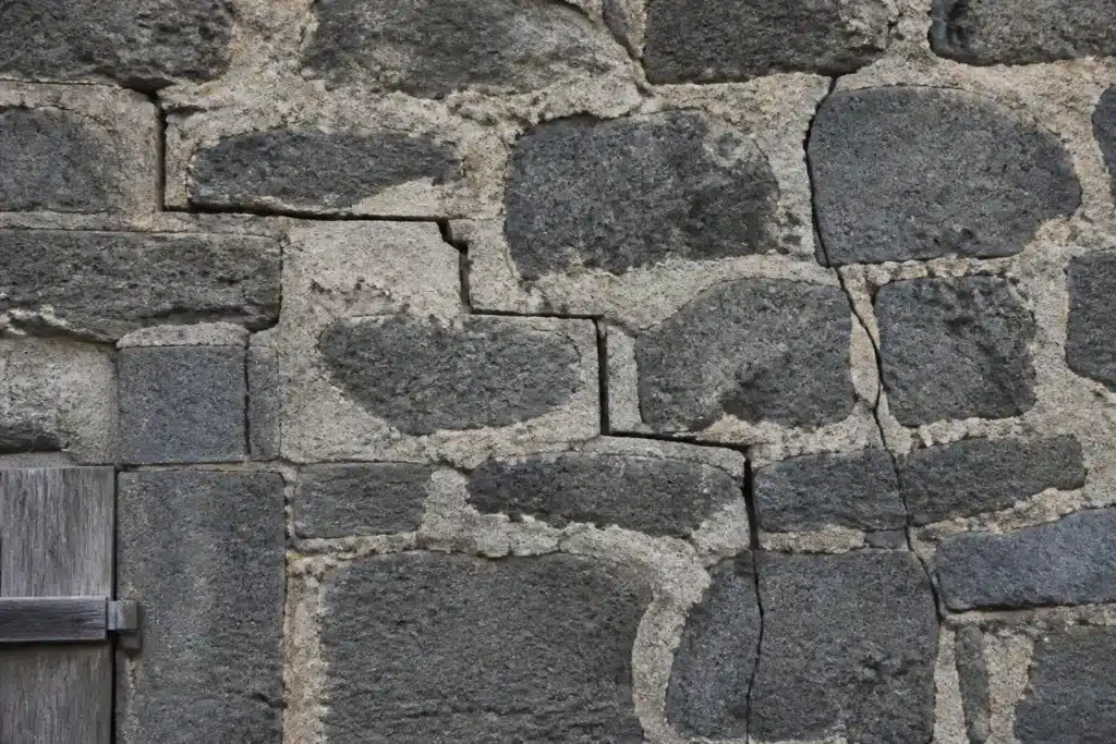 Plusieurs types de fissures sur un mur extérieur, à distinguer par l'expertise