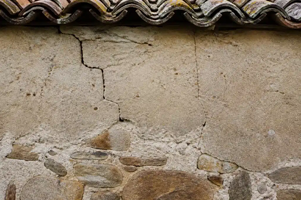 Plusieurs types de fissures sur un mur extérieur, à distinguer par l'expertise