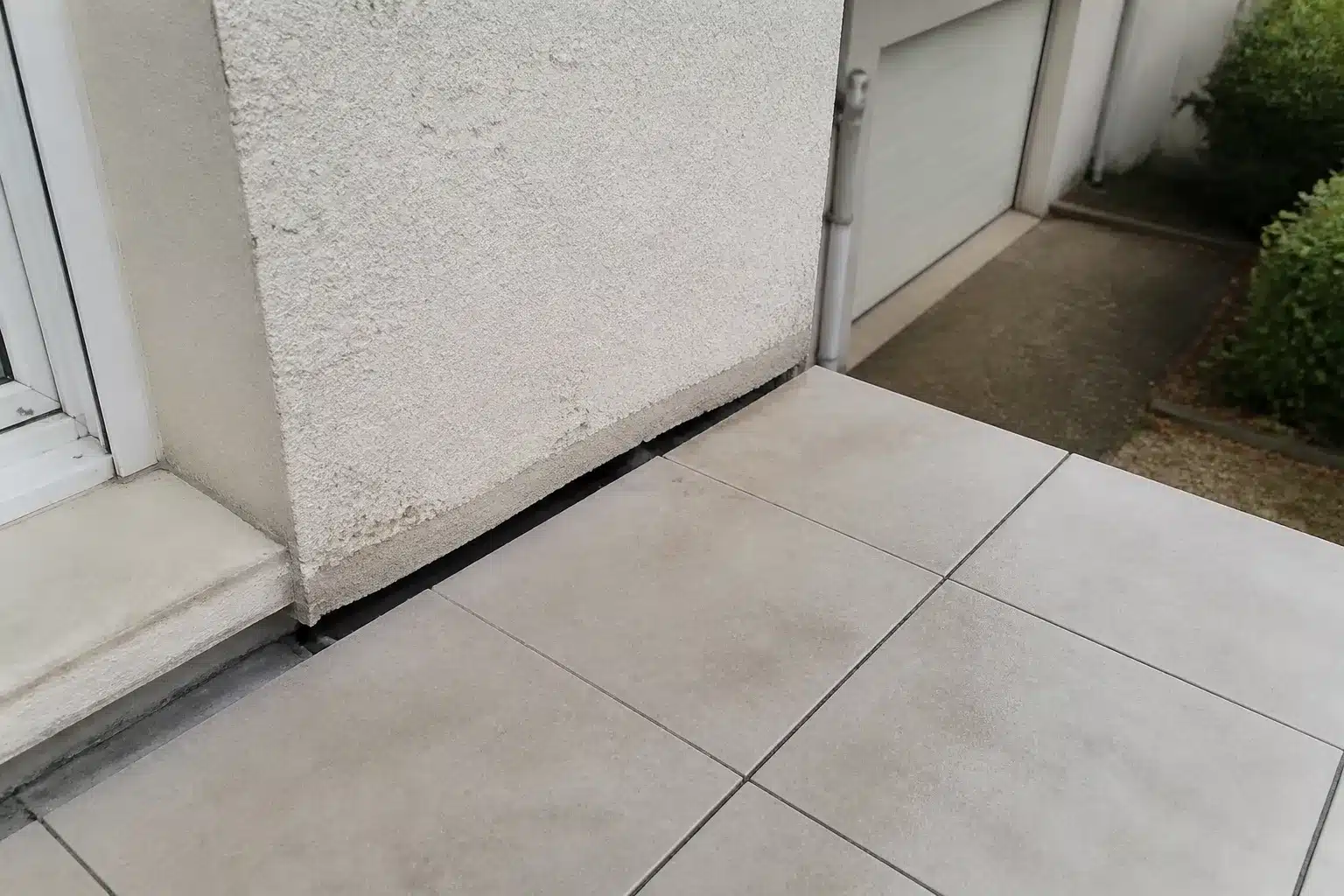 Joint ouvert entre le mur d'une maison et sa terrasse accolée affaissée