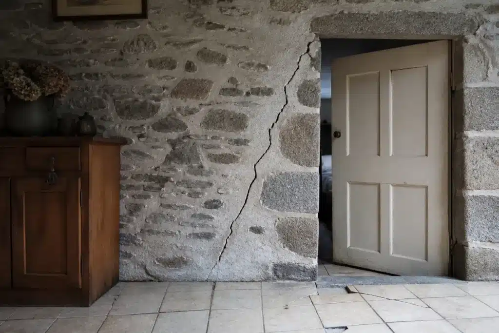 Fissure partant de l'angle d'une porte intérieure, indice de mouvement du sol