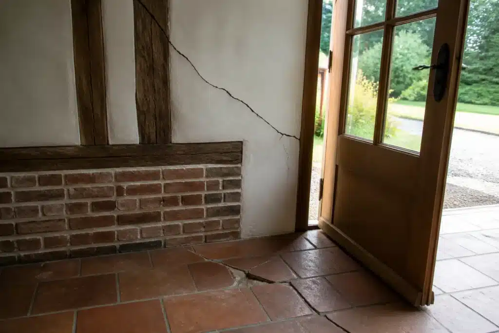 Fissure partant de l'angle d'une porte intérieure, indice de mouvement du sol