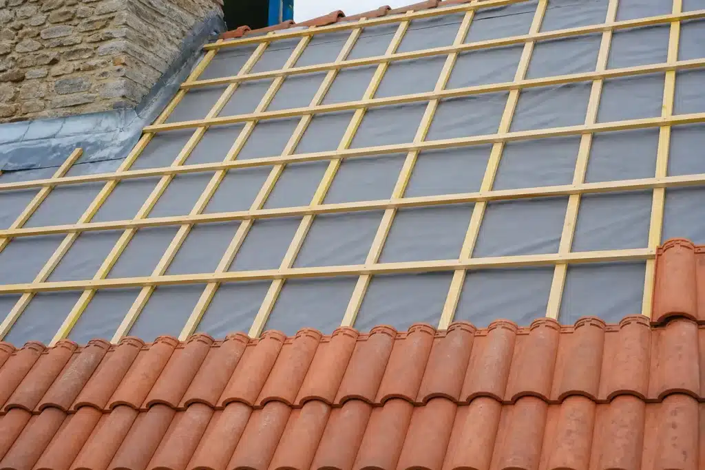 Versant de toiture en rénovation avec écran souple de sous-toiture tendu, contre-lattes et liteaux posés avant la couverture en tuiles