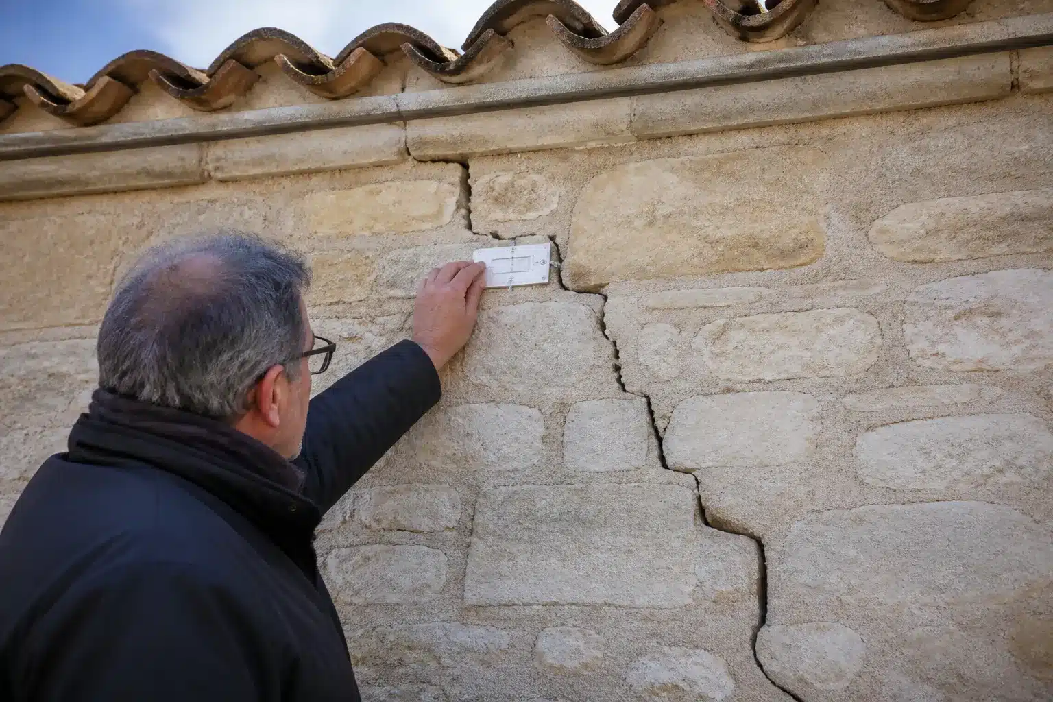 Expert mesurant une fissure de sécheresse sur une maison en Charente-Maritime