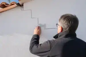 Expert mesurant une fissure de sécheresse sur une maison en Vendée