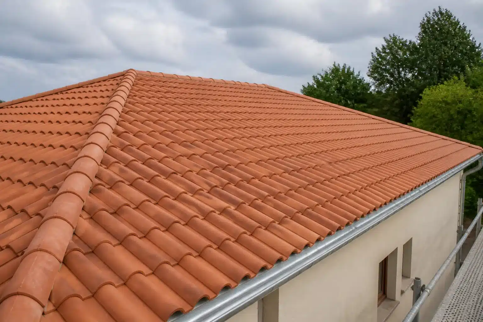 Toiture en tuiles de terre cuite entièrement refaite sur une maison individuelle, avec faîtage, rives et gouttière en zinc neufs