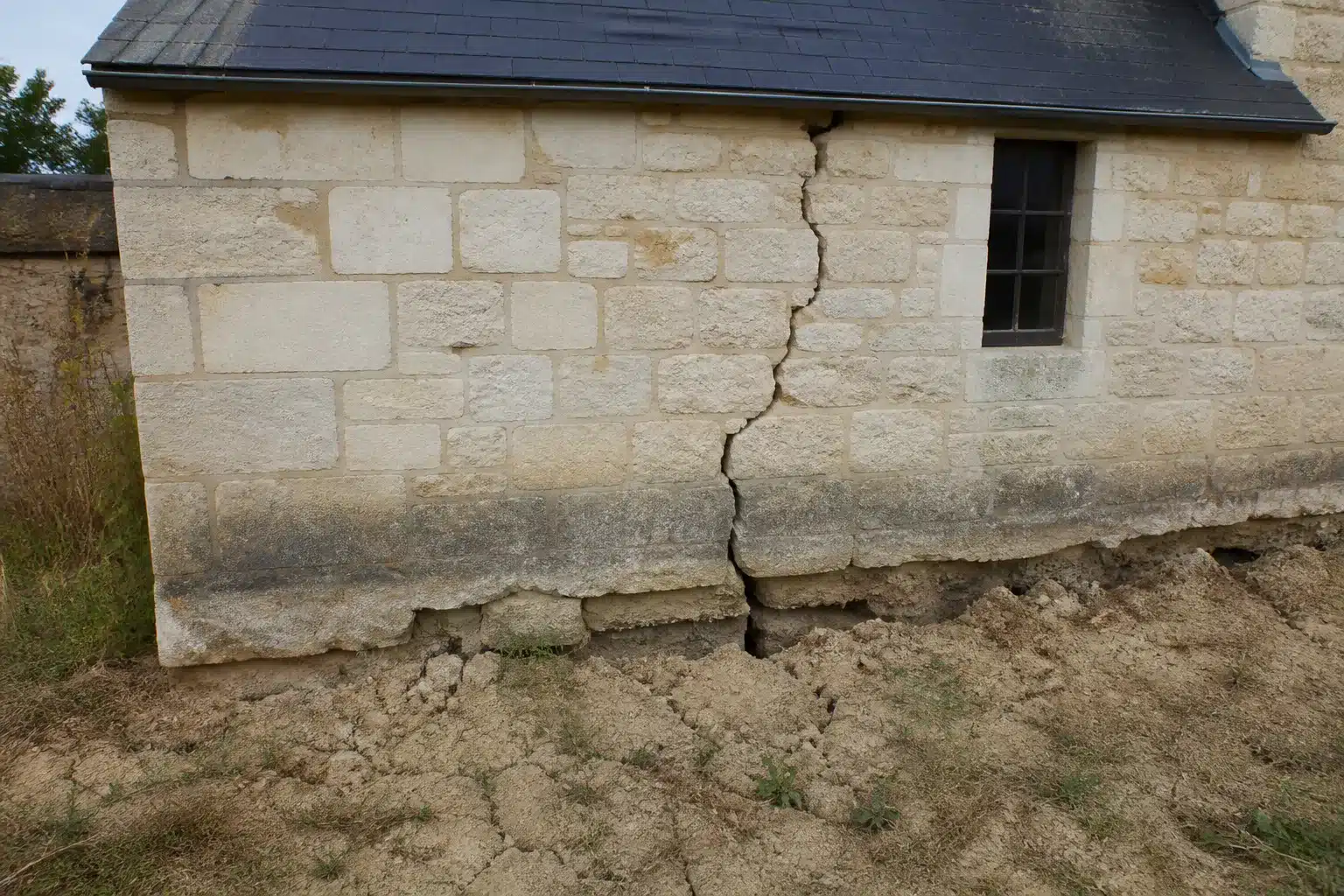 Sol argileux fendu au pied d'une maison dans le Loir-et-Cher, retrait-gonflement des argiles