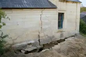 Sol argileux fendu au pied d'une maison en Maine-et-Loire, retrait-gonflement des argiles