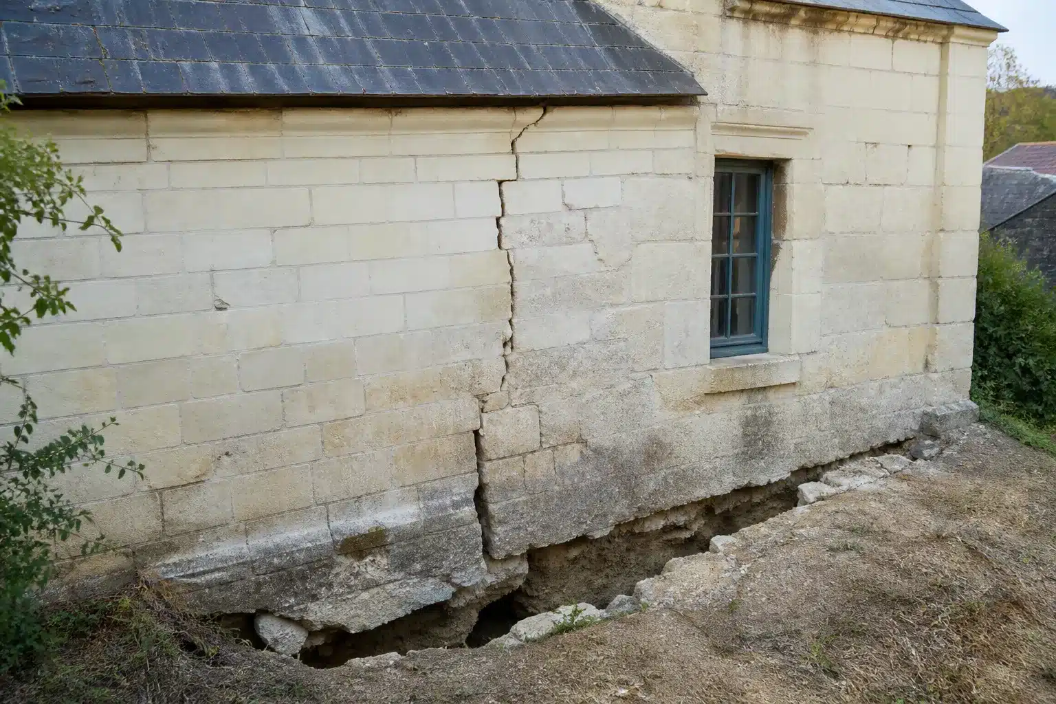 Sol argileux fendu au pied d'une maison en Maine-et-Loire, retrait-gonflement des argiles