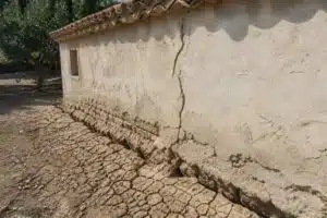 Sol argileux fendu au pied d'une maison dans le Vaucluse, retrait-gonflement des argiles