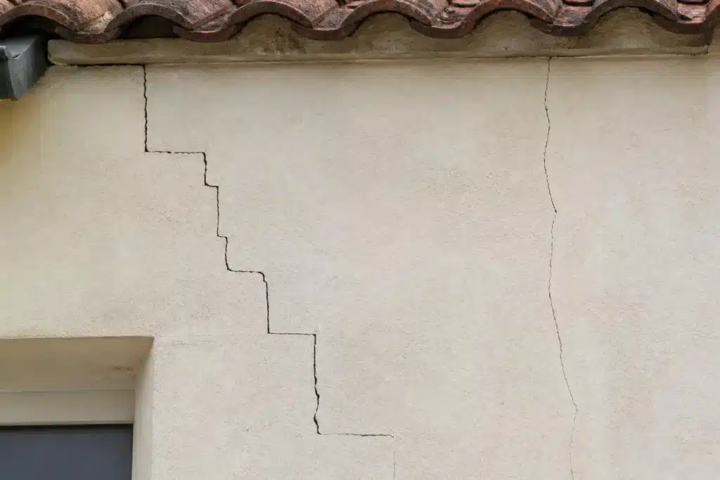Plusieurs types de fissures sur un mur extérieur, à distinguer par l'expertise